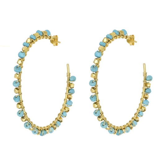 The Riva Turquoise Hoop earrings, from Mazzi D Fiori, contain miniature turquoise gemstones intricately hand-looped onto a gold frame with gold wire. &nbsp;These hoop earrings are lightweight and versatile for day or night wear, adding a unique touch to any outfit. The faceted semi-precious beads make a subtle statement while maintaining a delicate and sophisticated look.